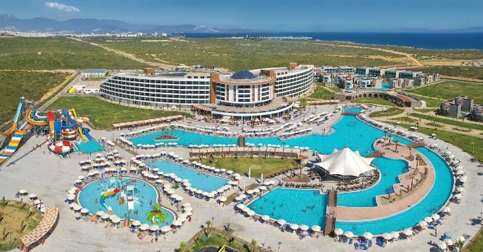 Didim Beach Resort Spa otelinin geniş yüzme havuzları ve su kaydıraklarının olduğu genel bir görünüm.