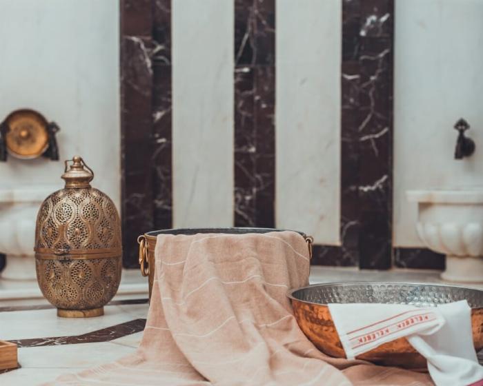 Geleneksel bir Türk hamamı içinde yer alan mermer göbek taşı ve otantik hamam sauna atmosferi.