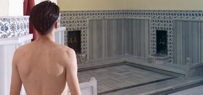 Profesyonel bir tellak tarafından mermer göbek taşı üzerinde yapılan geleneksel Türk hamamı kese ve köpük masajı ritüeli.