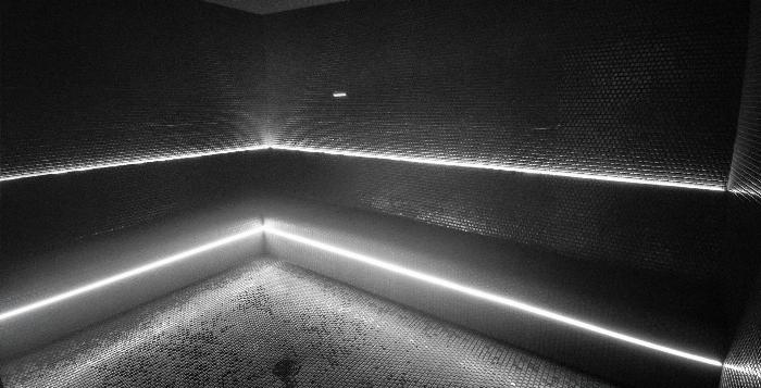 Saunalı ve buhar odalı spor salonlarında bulunan modern, mermer tasarımlı ve buharlı bir buhar odasının iç görünümü.